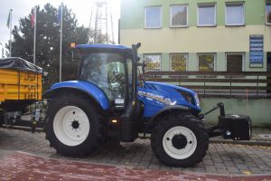 Nowy niebieski ciągnik stojący przed Urzędem Gminy