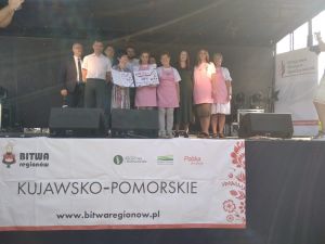 Grupa ludzi na scenie pozuje do zdjęcia